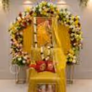 Guru Ji Birthday decoration with a floral background, a ceremonial chair in yellow, a framed portrait, and fresh flower garlands.