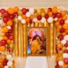 Devotional birthday celebration with framed Guru Ji portrait, balloon arch and table covered in white.