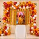 Elegant Guru Ji birthday backdrop with marigold garlands, balloon decorations and a spiritual portrait display.