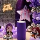 Character Standees Around A Silver Sequin Panel, Decorated With Purple Balloons For A Children's Birthday Party.