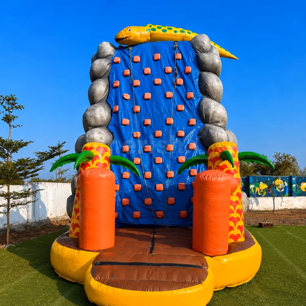 Large inflatable rock climbing activity for kids featuring a vibrant climbing wall, tropical-themed décor, and supervised outdoor adventure.