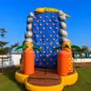 Large inflatable rock climbing activity for kids featuring a vibrant climbing wall, tropical-themed décor, and supervised outdoor adventure.