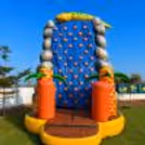 A colourful dinosaur climbing structure featuring a blue base and orange climbing rings.