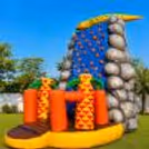 Side view of protective inflatable barriers, design resembling rock, and a large outdoor play area.