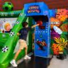 Digital boxing strength machine beside a hanging punch ball for visitors to play.