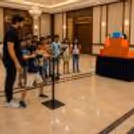 Person pointing launcher at Angry Birds block tower during a party activity.