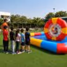Kids standing in a queue, child having fun in the colourful inflatable water zorb in a big outdoor pool.