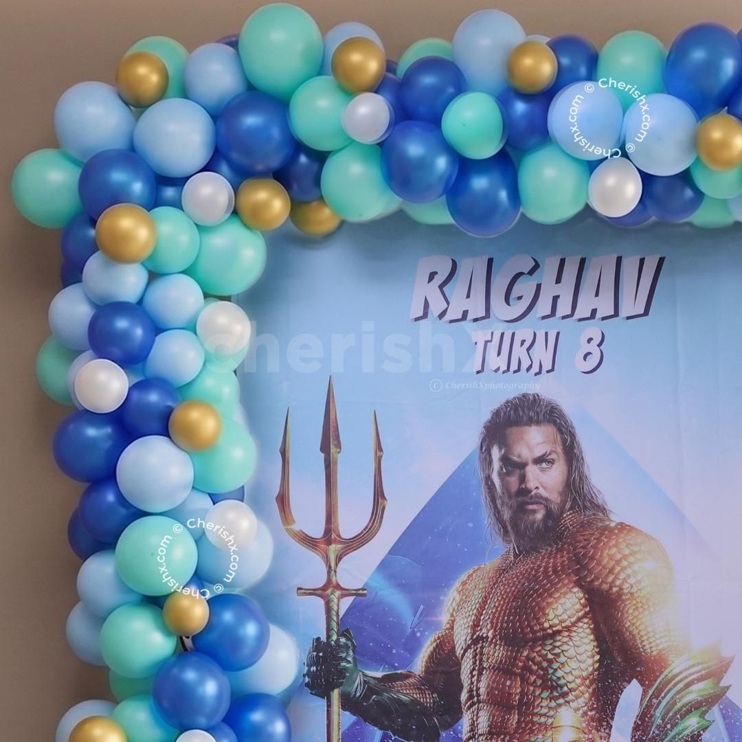 Big And Small Blue, Aqua, White, And Golden Balloons With A Customised Aquaman Poster.