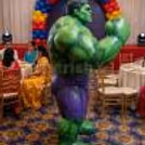 Close-up of an inflated superhero costume with a muscular body, purple shorts and a detailed facial expression.