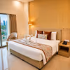 Spacious luxury hotel bedroom featuring a comfortable king bed, stylish décor, bedside lighting, and premium furnishings.
