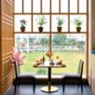 Elegant window-side dining table featuring sushi platter, refreshing mocktails, candlelight décor, and a scenic outdoor view.