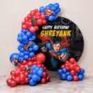 Personalised birthday ring stand with red and dark blue balloon garland, forming a superhero birthday theme.