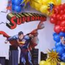City skyline painting and colourful balloon design and decorations on a unique superhero-themed ring backdrop.