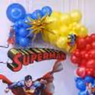 Custom circular flex with colourful balloon decorations, Superman logo close-up.