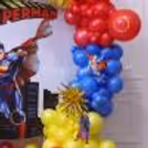 Superman cut-outs and blue and red balloon arrangements, and a golden 4D balloon.