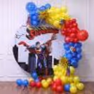 Superman ring stand with red, blue, and yellow balloon garland, 4D star balloons and cutouts.