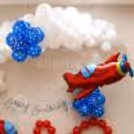 Party arrangement at top with balloon clouds above, balloon accents blue, airplane flying in sky theme.