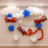 Fully decorated airplane birthday with floating white balloon clouds, 3 red airplane foil balloons, blue balloon clusters, and a silver Happy Birthday banner.
