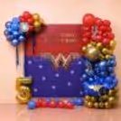 Wonder Woman birthday flex with red, blue and golden clusters of balloons and a golden age foil balloon.