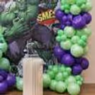 Green And Purple Organic Balloon Decoration Around A Hulk Birthday Backdrop With Superhero Theme.