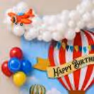 Close up of groups of balloon clouds around printed party panel with floating air balloon artwork.