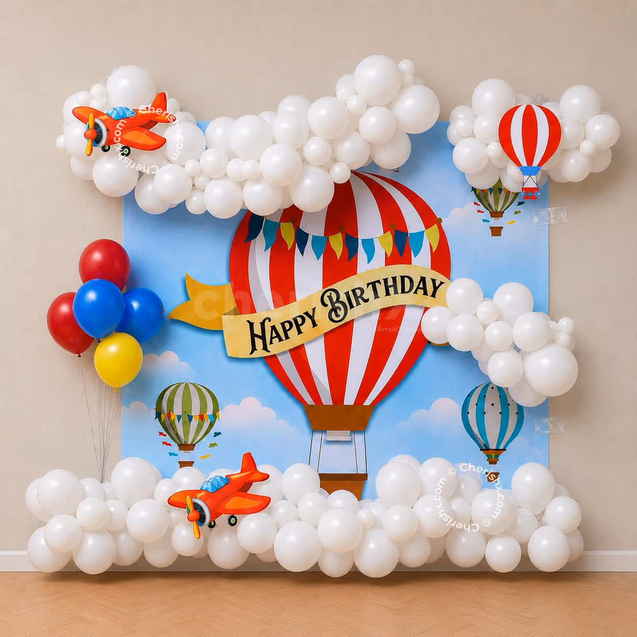Sky-inspired party display with fluffy white cloud balloons, airplane foil balloon and colourful celebration wall.