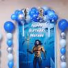 Special birthday panel featuring Aquaman character, glittery blue curtains and aquatic decorations in the centre.