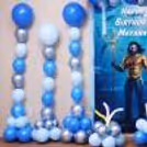 Superhero-themed party with a sea touch and themed character cutout and clusters of floor balloons.