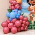 Bottom of festive decor with cascading layers of blush pink and pastel blue balloons and decorative flowers.