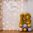 A playful backdrop of balloons and fairy light draws attention instantly