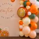 The message 'A Little Cutie Is On The Way' is displayed with elegant typography, fruit illustrations, and soft pastel styling in close-up.