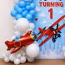Balloon backdrop with cutout of flying airplane and cloud theme design.