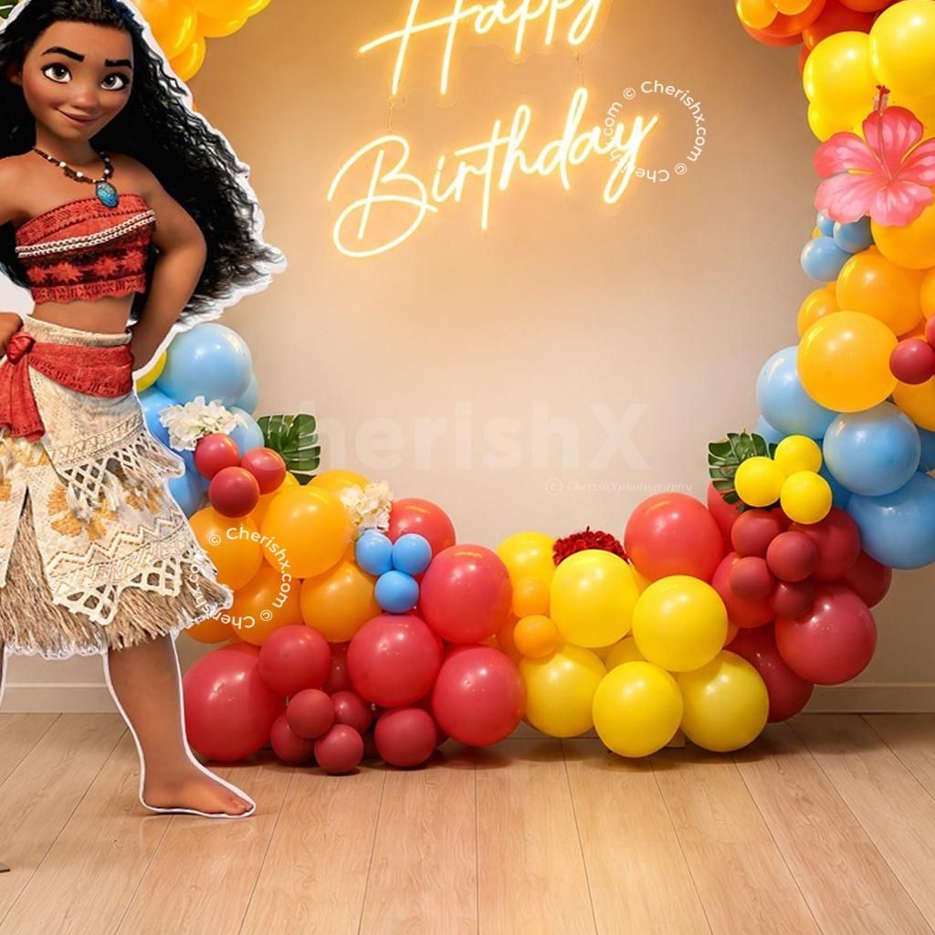 Bright pink, yellow, orange and blue balloon arches around a Moana birthday backdrop with tropical flowers.