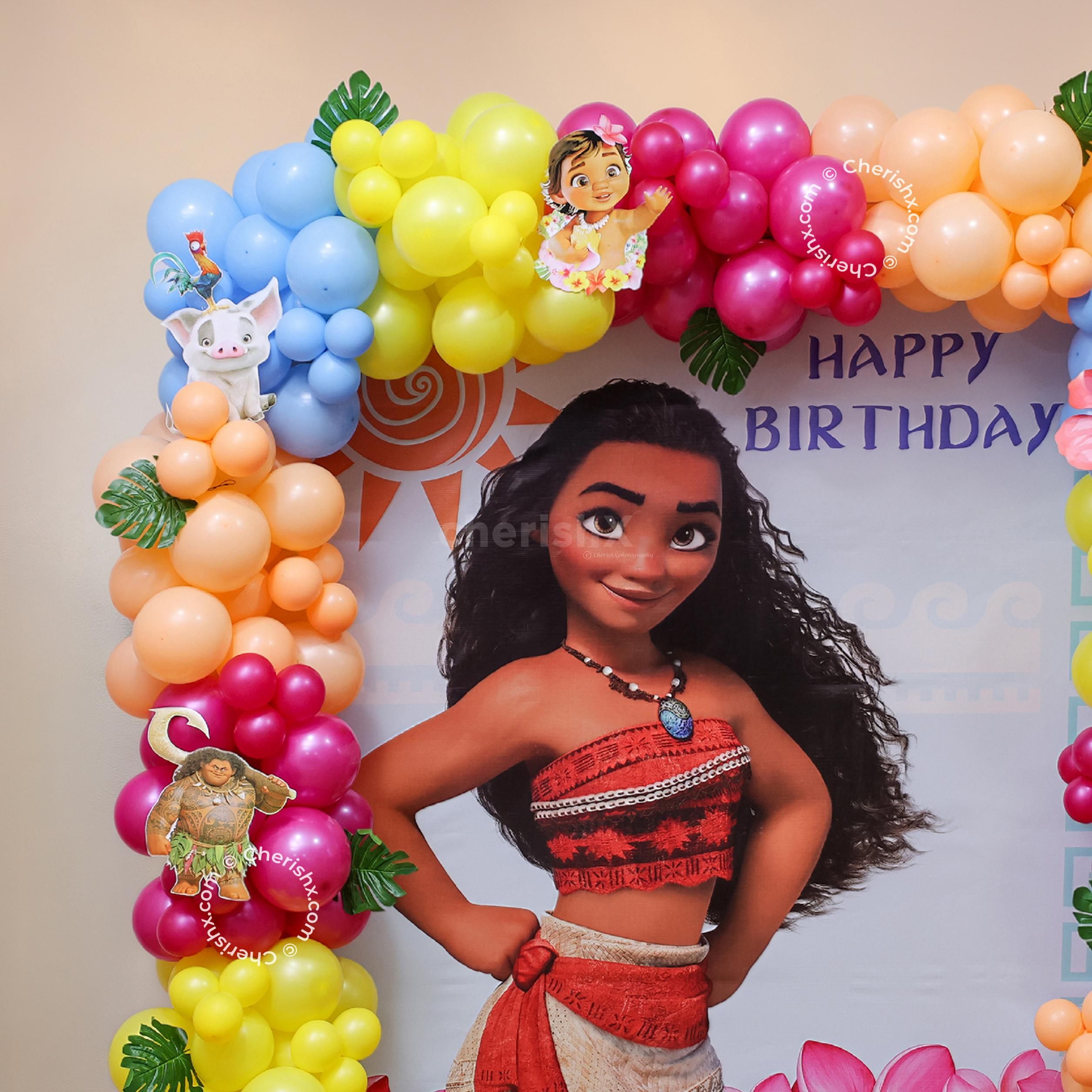 Tropical party decorations with green leaves, flowers and character cutouts.