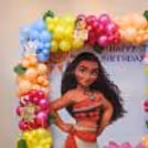 Tropical party decorations with green leaves, flowers and character cutouts.