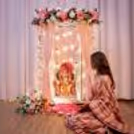 Golden stand, pink georgette drapes, fairy lights, and floral decoration around the backdrop of Blush Blossom Ganesh Chaturthi.