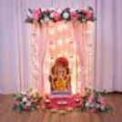 Gold with blush pink flowers, flowing draped cloths, hanging ornaments and lit festive stuff for Ganesh Chaturthi.