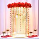 Red rose flower arrangement with hanging yellow and red flower strings around the setup.