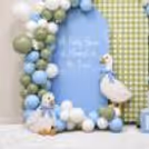 Green and blue balloon setup for a baby party with personalised backdrop.