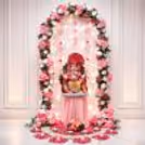 Beautiful Ganpati idol with pink and white flowers around and a setup wall.