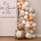Personalised baby welcome sign with soft apricot and white balloons.