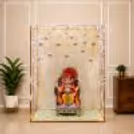 Golden cuboid frame, crystal mirror Ganpati setup with shimmering curtain backdrop.