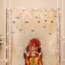 Ganpati idol with white floral flooring and soft warm lights around it.