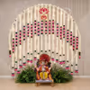 Simple and beautiful Ganpati backdrop with fairy lights, pink lotus garlands and green leaf decoration around the idol area.