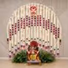 Simple and beautiful Ganpati backdrop with fairy lights, pink lotus garlands and green leaf decoration around the idol area.