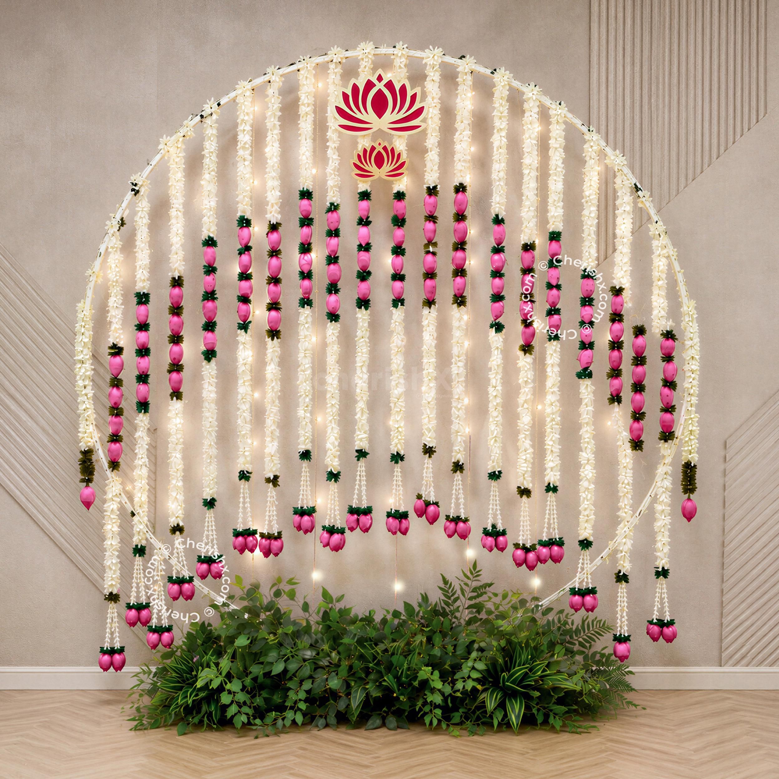 Floral garlands with lotus ring decoration, warm lighting and a beautifully styled backdrop for a Ganpati celebration.