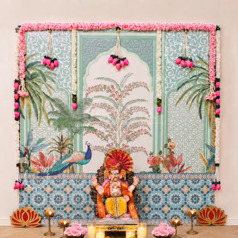 Peacock Theme Traditional Ganpati Backdrop with best peacock design flex backdrop, Pink floral garlands, Lotus strings and festive pooja decoration.