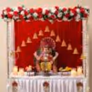 Golden frame to decorate with artificial jasmine strings, white and red flower garland, festive bell for Ganpati celebration.