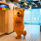 Close-up of the happy Bear mascot setting up photos and having fun with kids at a party.