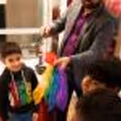 A boy is having a magic birthday party with a professional magician who is doing a colourful magic trick for him.